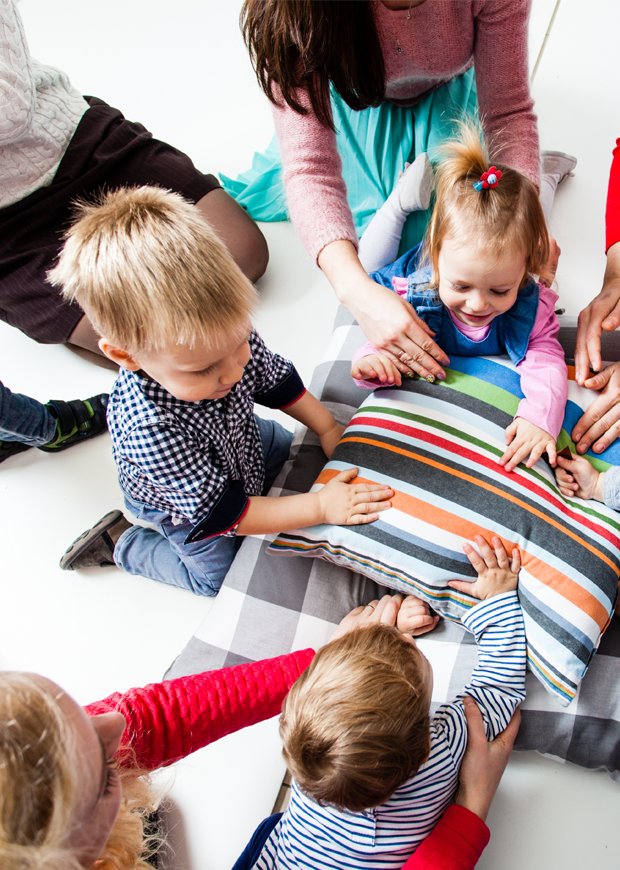 Young children in a group with parents and guardians